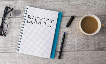 budget text on notepad with coffee on tableの写真素材