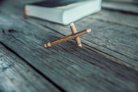 Close-up shot of holy bible with cross on wooden table.の写真素材