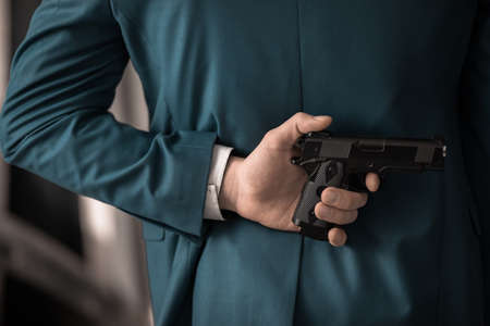 man hand gun on backの写真素材