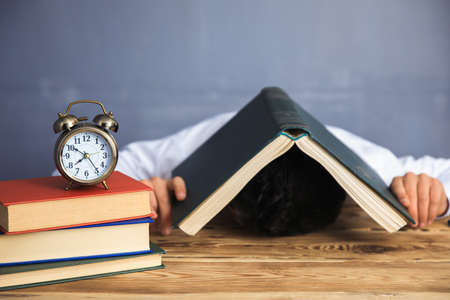man sleeping head book with hand clock