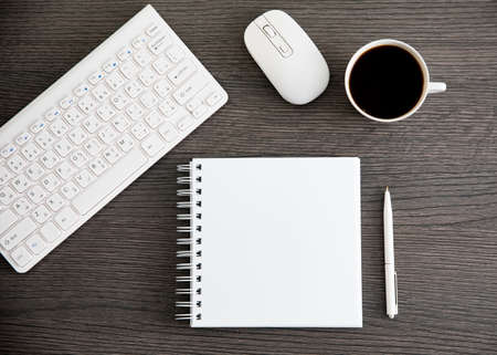 notepad with keyboard and coffee on deskの写真素材