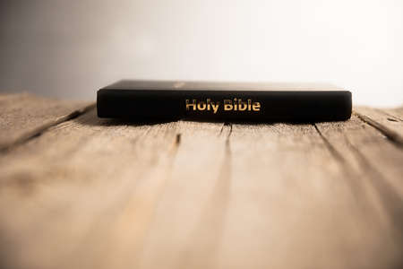 Holy Bible on the wooden table backgroundの写真素材
