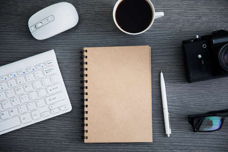 notepad with keyboard and camera on tableの写真素材