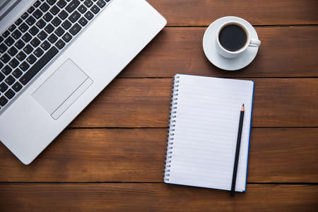 notebook with notepad and cup of coffee on table