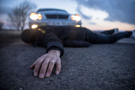 young man lying on roadat sunset