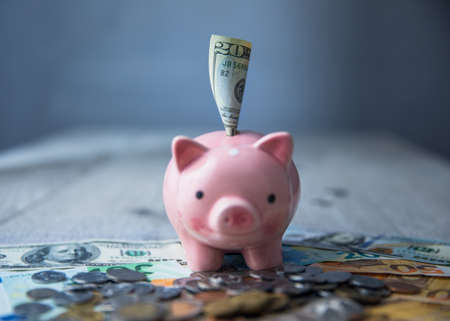 piggy bank with money and coins on deskの写真素材