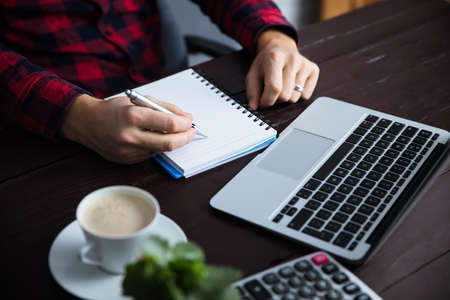 man hand notepad and keyboard on desk