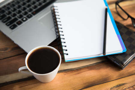 notepad on keyboard with coffee on deskの写真素材