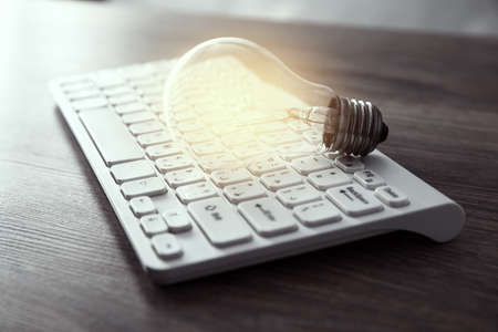 idea or light bulb on keyboard on tableの写真素材