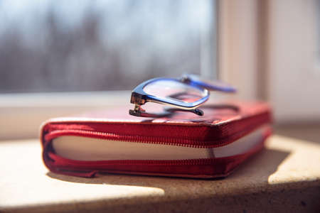 glasses on book on the windowの写真素材