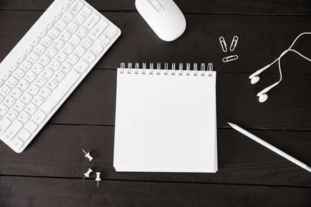 notepad with keyboard and stationary on deskの写真素材