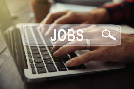 man hand keyboard with jobs text in screenの写真素材