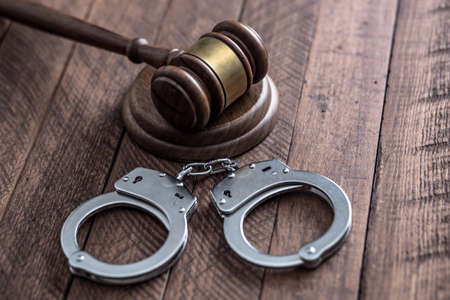 judge with handcuffs on tableの写真素材