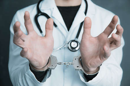 young man doctor hand handcuffs