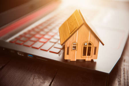 wooden house model on keyboard on deskの写真素材