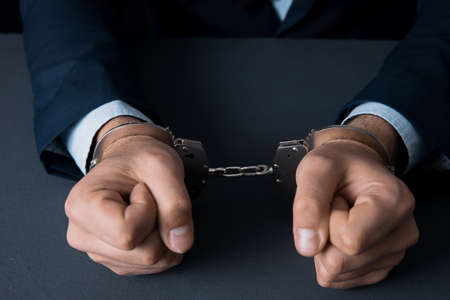 man hand handcuffs on the desk