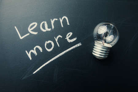 learn more text with bulb on boardの写真素材