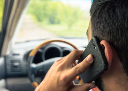 man driving car and calling on smartphone backgroundの写真素材