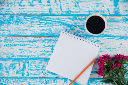 notepad with flowers and coffee on the desk