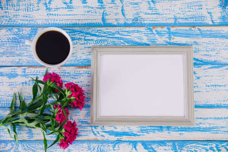 Frame photo with flowers and coffee on the desk