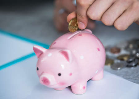 man hand coins with piggy bank on deskの写真素材