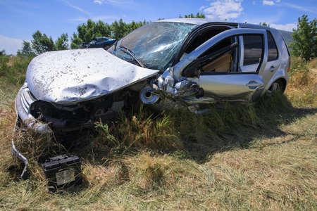 broken car in grass under skyの写真素材
