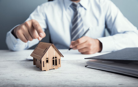 man hand document with house model on deskの写真素材
