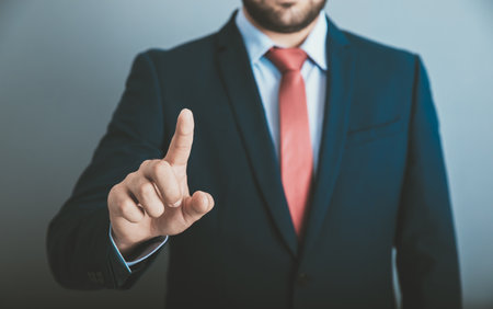 man finger touching in screen on dark backgroundの写真素材