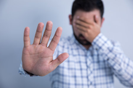 sad man hand stop sign on gray background