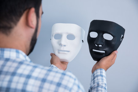 man hand white and black mask on gray background