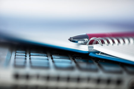 pen with notepad and calculator on deskの写真素材