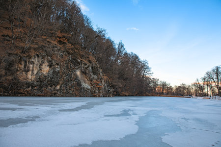 frozen lake with forest under sky backgroundの写真素材
