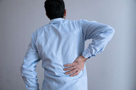 man hand in ache back on gray background