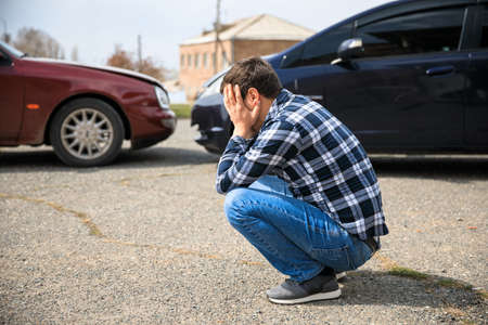 sad man and car crash in the streetの写真素材