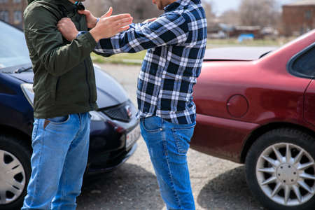 fighting men with car accident in street