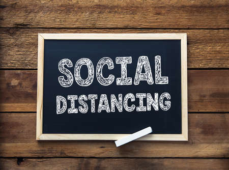 social distancing on chalkboard on the table backgroundの写真素材