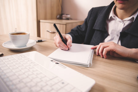 woman hand notepad with computer on the tableの写真素材