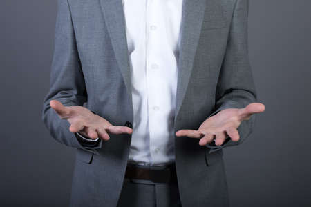 young businessman empty hand on gray backgroundの写真素材