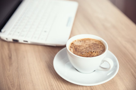 cup of coffee with computer on tableの写真素材