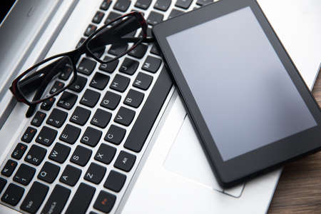 tablet and glasses on computer on table