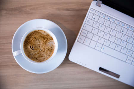 cup of coffee and computer on the tableの写真素材