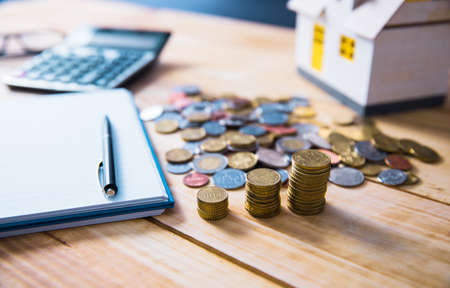 coins with documet and house model on the table