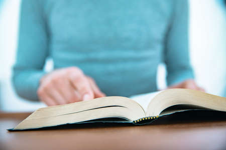man reading Holy Bible on the table