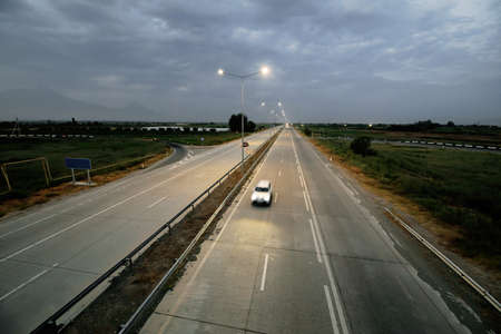 Countryside highway and car at nightの写真素材