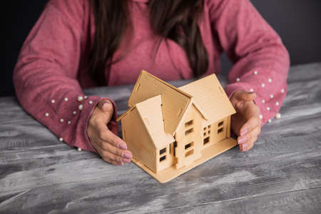 young woman hand house model on the tableの写真素材