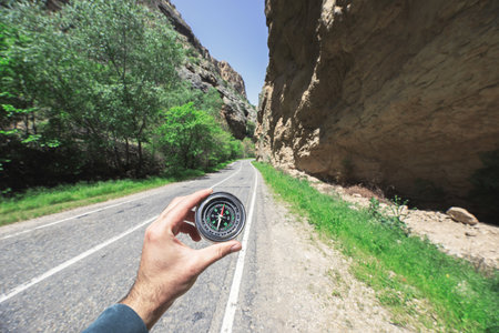 man hand compass in asphalt road background