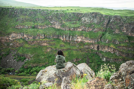 young traveler woman sitting in the rockの写真素材