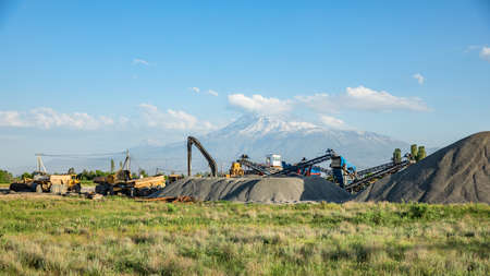 Construction machine and building material in Ararat mountain background