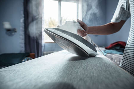 woman ironing her clothes in room backgroundの写真素材