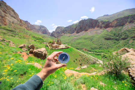 man hand holding compass in rock backgroundの写真素材